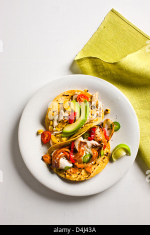 Shredded Chicken Tacos with Tomatoes, Avocado and Grilled Corn + Sautéed Tilapia Tacos with Colored Peppers and Grilled Onion. Stock Photo