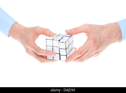 Male hands in shirtsleeves solving a blank white twist puzzle. Isolated on white. Stock Photo