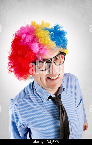 Funny businessman with clown wig on gray background Stock Photo