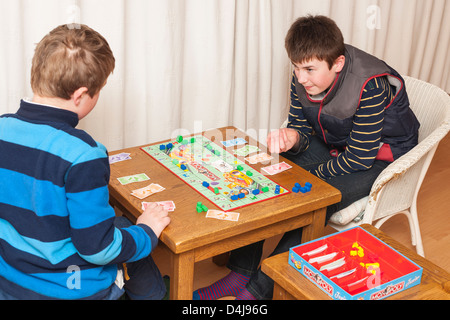 Two boys ( brothers ) playing junior monopoly board game at home Stock Photo