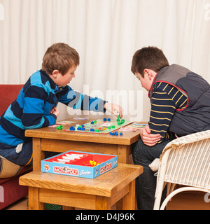 Two boys ( brothers ) playing junior monopoly board game at home Stock Photo