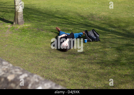 Young man lying on grass in park Stock Photo