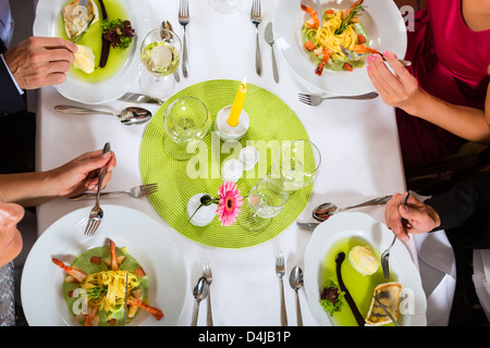 Two couples dining in fine restaurant enjoying the good food Stock Photo