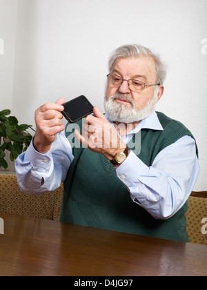 Senior man checking his new smart phone Stock Photo