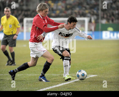 German midfielder Mesut Oezil (R) vies for the ball with Erik Huseklepp from Norway during the international match at LTU Arena in Duesseldorf, Germany, 11 February 2009. Norway defeated Germany 1-0. Photo: Federico Gambarini Stock Photo