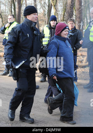 Officers of SEK (German special police forces) lead an environmental activist away from the protestors? forest camp in Kelsterbach, Germany, 18 February 2009. The police surrounded the camp in the early morning of 18 February and cleared the cottages on the ground. However, more environmental activists still entrench themselves in several tree houses. Photo: BORIS ROESSLER Stock Photo