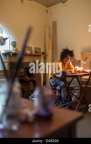 Woman using tablet computer at desk Stock Photo