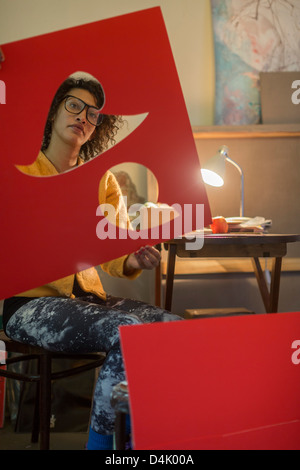 Artist cutting out red cardboard Stock Photo