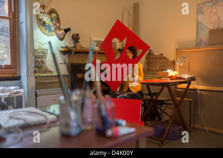 Artist cutting out red cardboard Stock Photo