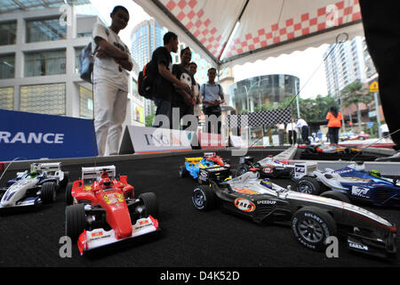 Motor sport fans play with small remote controlled Formula One racing cars on a motor-racing circuit in Kuala Lumpur City Center (KLCC) in Kuala Lumpur, Malaysia, 01 April 2009. The Formula One Malaysian Grand Prix will take place at Sepang International Circiut near Kuala Lumpur on 05 April 2009. Photo: PETER STEFFEN Stock Photo