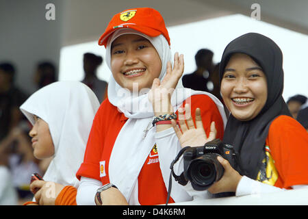 Teenage F1 fans smile before the start of the Malaysian Grand Prix at Sepang circuit, outside Kuala Lumpur, Malaysia, 05 April 2009. Photo: JENS BUETTNER Stock Photo