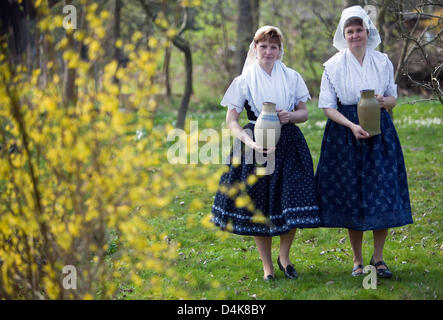 (Illustration) - Kerstin Krause (L) and Carola Zeidler wearing the traditional costume of the Spree Forest carry ?Easter water? in jugs from a stream in Lehde, Germany, 06 April 2009. The fetching of the ?Easter water? is part of a long custom in the Sorbian area. Women and girls draw water from a stream or a well on the night before Easter Sunday. Talking is not allowed on the way Stock Photo