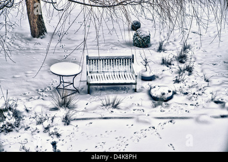 Bench and table on snowy street Stock Photo