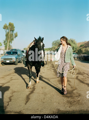 Woman walking horse on suburban street Stock Photo