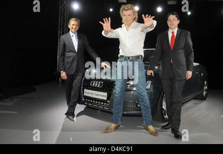 Magician Hans Klok poses between Thomas Guenther (L), marketing director of Audi for Southern Germany, and Christoph Siedenhans, director of the car dealership Audi Munich West, during the presentation of the new Audi A5 cabriolet in Munich, Germany, 22 April 2009. Photo: Felix Hoerhager Stock Photo