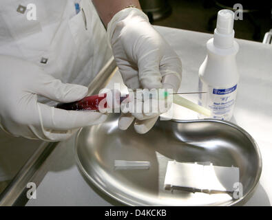 A medical secretary removes the needle from a syringe filled with blood in an AIDS information centre in Hamburg, Germany, 24 April 2009. Photo: Angelika Warmuth Stock Photo