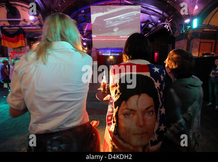 Michael Jackson fans shed tears as they watch a live coverage of the