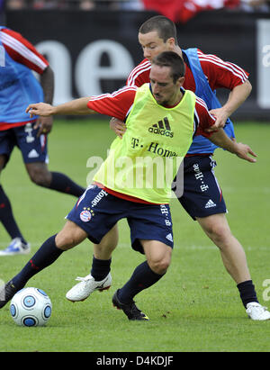 French Franck Ribery (front) and new arrival Alexander Baumjohann of German Bundesliga club FC Bayern Munich fight for the ball during a training session at the club?s grounds in Munich, Germany, 08 July 2009. Spanish club Real Madrid only sees a slight chance to sign Ribery. Real Madrid?s general director Valdano announced that he did not have the feeling, Bayern Munich would let  Stock Photo