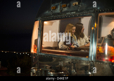 Couple relaxing with dog in trailer Stock Photo