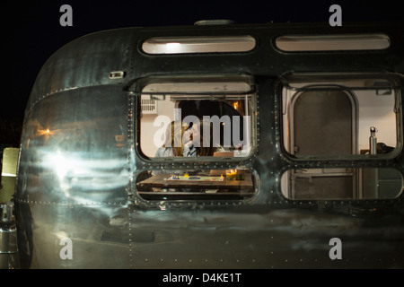 Couple kissing in trailer Stock Photo