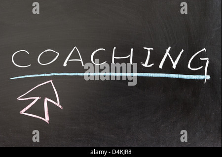 Coaching word and mouse pointer drawn on chalkboard Stock Photo