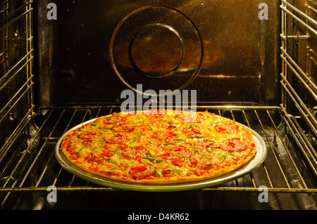 Homemade pepperoni pizza in oven Stock Photo