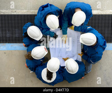 (dpa file)- A group of young engineers discusses construction plans in a chemical plant of Dow Chemical Company near Stade, Germany, 13 October 2008. The shortage of skilled labour in Germany is especially high with regard to engineers. By the so-called ?Bill On Regulation Of Labour Migration? the German Bundestag plans to diminish the obstacles for foreign skilled workers still fu Stock Photo