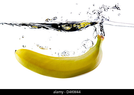 Banana fruit splashing into water on a white background Stock Photo