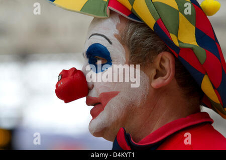 London, UK. 15th March 2013. A man wearing dressed as a clown with a red nose raising money for comic relief. Red Nose Day is a fundraising event organized by Comic Relief a British Charity raising money for projects at home and abroad to help disadvantaged people and bring about positive change in the lives of the poor.  Credit:  amer ghazzal / Alamy Live News Stock Photo