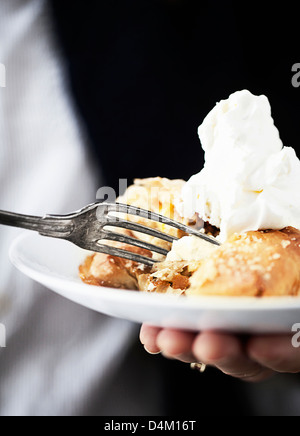 Plate of apple pie with cream