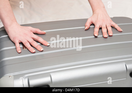 Woman packing suitcase in hotel room Stock Photo