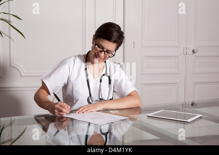 Doctor taking notes in office Stock Photo