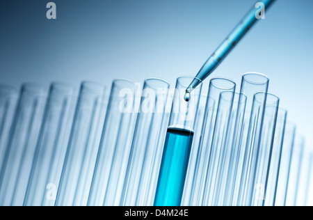 Medical pipette dropping liquid into test tube Stock Photo