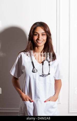 Doctor wearing stethoscope in office Stock Photo