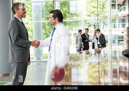 Businessman and doctor shaking hands Stock Photo