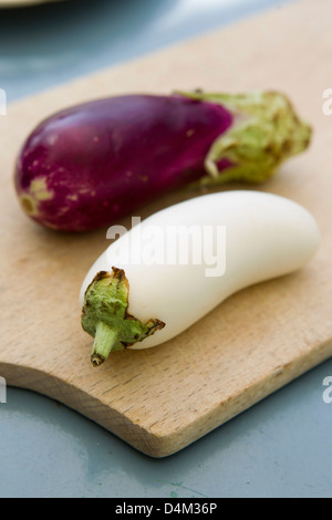 White and purple eggplants on board Stock Photo