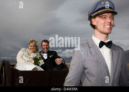 Man driving newlyweds in wooden cart Stock Photo