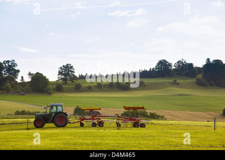 Tractor driving in rural field Stock Photo