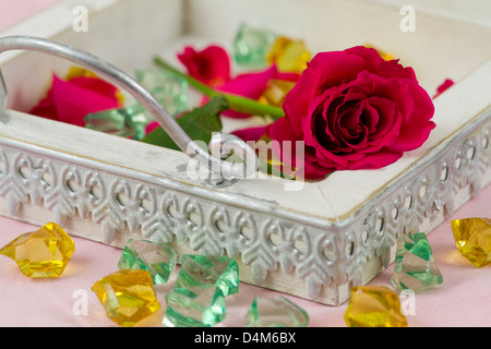 vintage tray with red rose, rose petals and crystals Stock Photo