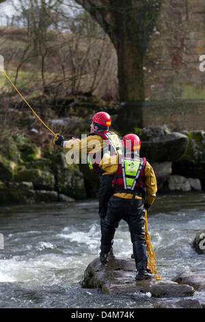 Swiftwater and Flood Rescue Technician course. Trainee Firemen at Devil's Bridge in Kirby Lonsdale, England Friday 15th March, 2013.  Members of the Barrow-in-Furnace and Kendal Swiftwater and Flood Rescue Technician course. Fire Service Rescue Unit, wearing Petzl safety helmets and Rescue 800 PFD Bouyancy Aid with Aqua-Tek X480 Scuba Diving Dry Suit, undergoing annual flood & Swift Water Rescue 3 Training on the River Lune at Kirby Lonsdale, Cumbria, UK. Stock Photo