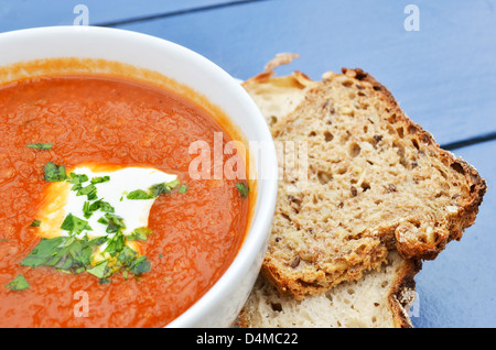 Tomato soup with basil and fresh black bread closeup Stock Photo