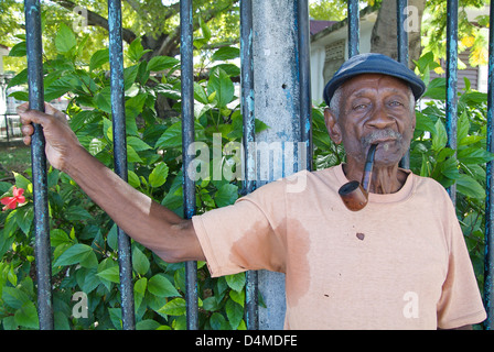 Havana, Cuba, old man with a pipe holds on to a fence Stock Photo