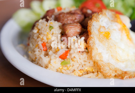 Close up of fried rice with pork and fried egg on top