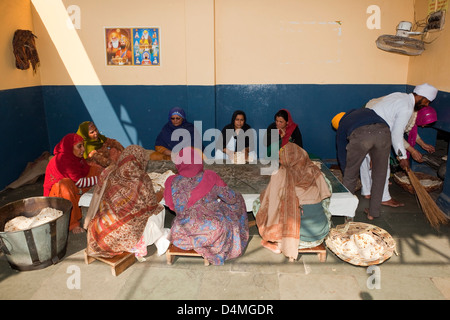 A group of women stacking chapattis in the free kitchen at the Golden Temple Amritsar Punjab India Stock Photo