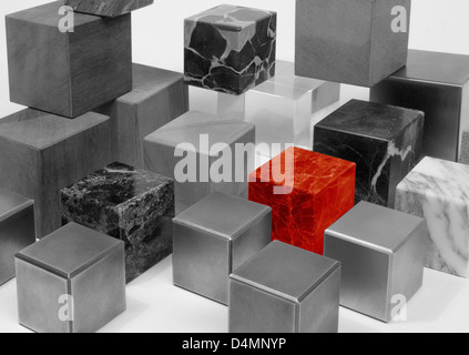 various cubes made of different materials, black and white toned including a outstanding red one Stock Photo