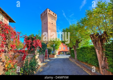 View of red brick tall tower of medieval castle under clear blue sky on sunny day in town of Santa Vittoria D'Alba in Italy. Stock Photo