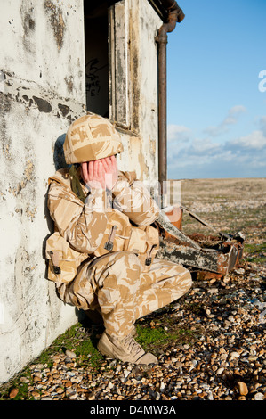 Soldier suffering with Post Traumatic Stress Disorder on the battlefield. Soldier is wearing British military desert uniform. Stock Photo