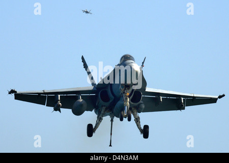 A US Navy F/A-18C Hornet fighter aircraft prepares to land aboard the aircraft carrier USS John C. Stennis March 9, 2013 in the Arabian Sea. The John C. Stennis is operating in the Arabian Sea in support of operations in Afghanistan. Stock Photo