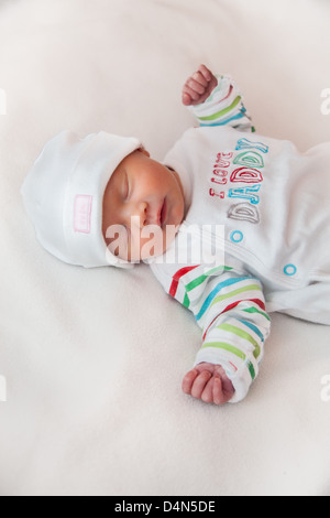 Baby girl (8 days old) taken in a very soft light (a light tent). Hat reads 'cute' and top reads 'I love Daddy'. Stock Photo