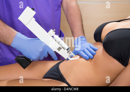 abdominal mesotherapy gun therapy doctor to beautiful woman Stock Photo